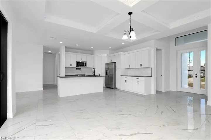 Kitchen with appliances with stainless steel finishes, dark countertops, open floor plan, recessed lighting, and decorative backsplash