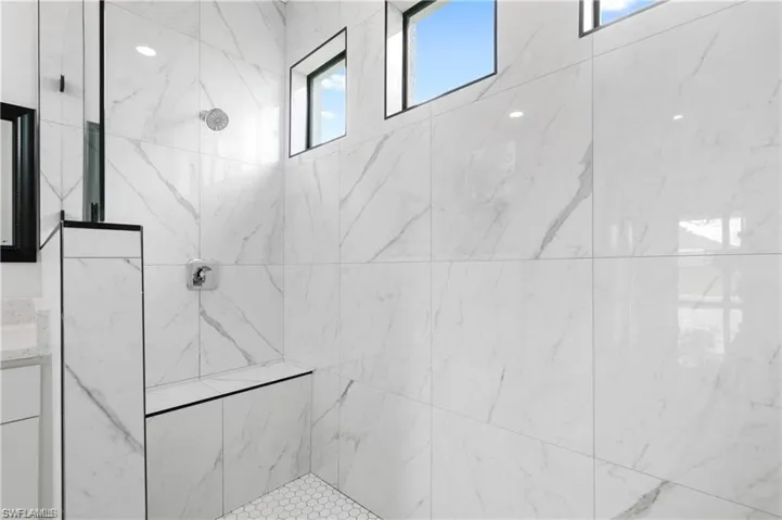 Full bathroom featuring a marble finish shower and vanity