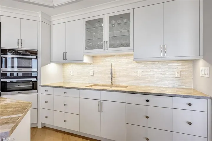 A stunning backsplash, custom cabinetry, and high-end appliances elevate the space.