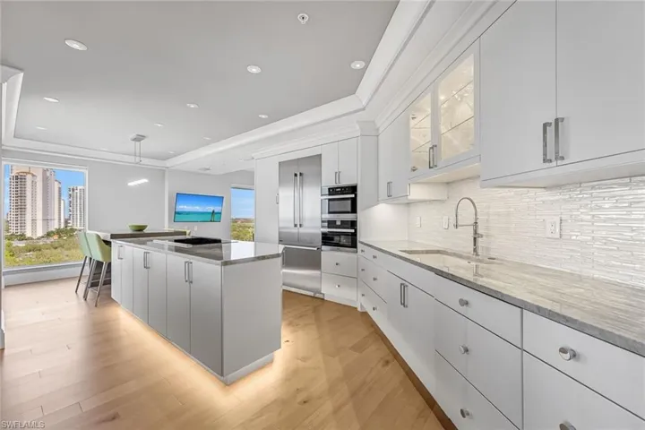Under-island accent lighting creates a subtle floating effect adding depth and elegance to the kitchen.
