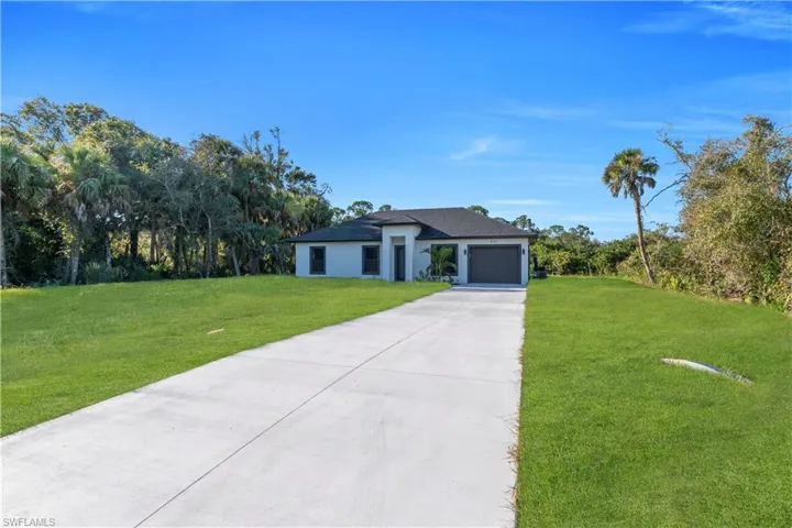 Contemporary single-story residence featuring a gray exterior with dark trim and a dark shingle roof