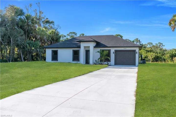 Contemporary residence featuring a clean white exterior and a dark shingle roof
