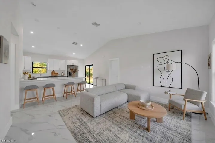 Spacious living area featuring high vaulted ceilings and large format tile flooring