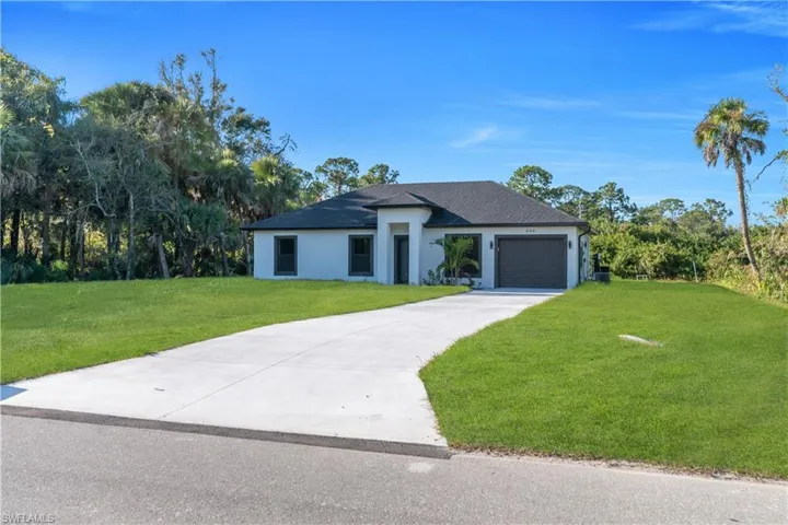 Modern stucco residence featuring a dark shingle roof, attached garage with a dark door, and a concrete driveway