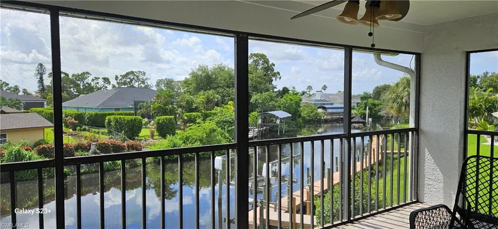 Unfurnished sunroom with a ceiling fan, a water view, and healthy amount of natural light