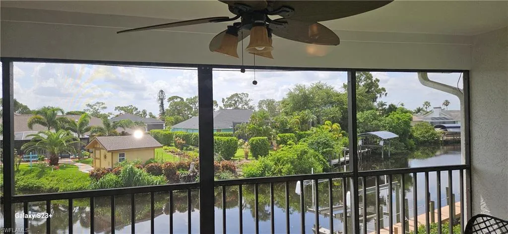 Unfurnished sunroom with a ceiling fan and a water view
