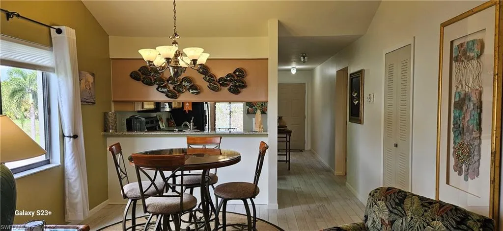 Dining area with light wood-type flooring and a chandelier