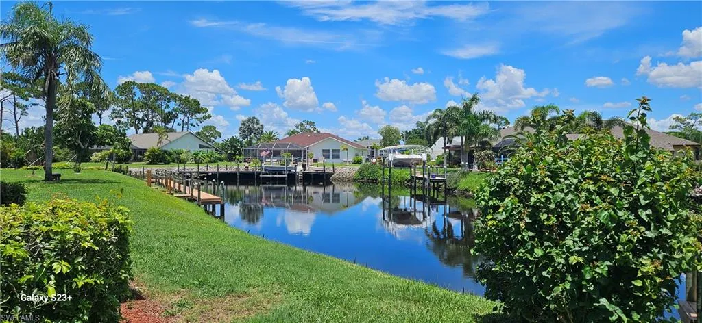 Water view featuring nearby suburban area and a dock