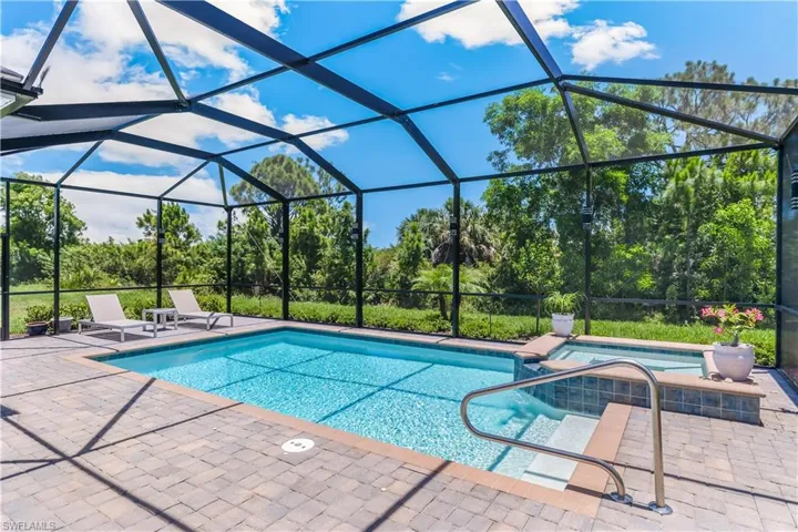 View of pool with an in ground hot tub, a patio, and a lanai