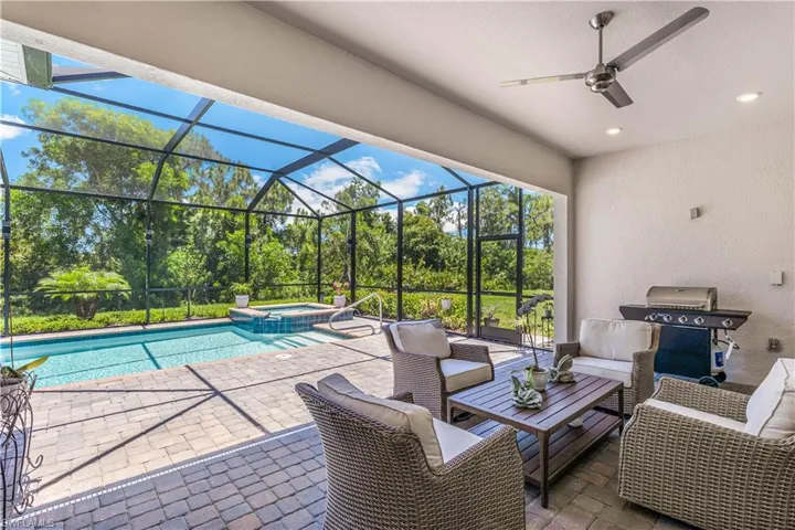 View of pool with a lanai, outdoor lounge area, an in ground hot tub, ceiling fan, and a patio