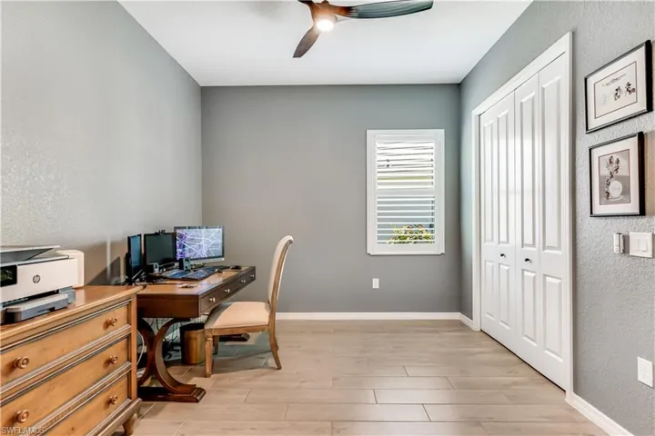 Home office with ceiling fan and light wood-type flooring