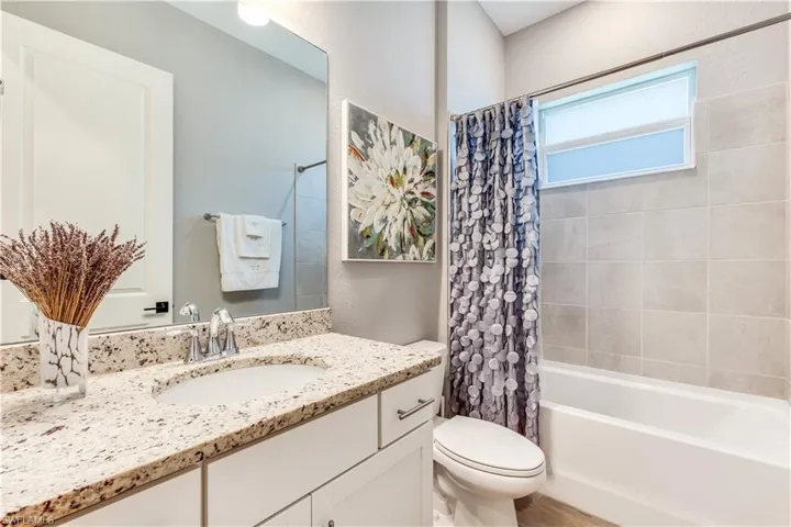 Full bathroom featuring shower / tub combo, toilet, and large vanity