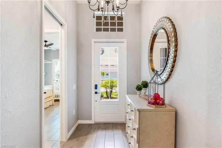 Entryway featuring light hardwood / wood-style flooring and ceiling fan with notable chandelier