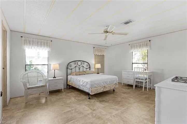 Bedroom with visible vents, a textured ceiling, and a ceiling fan
