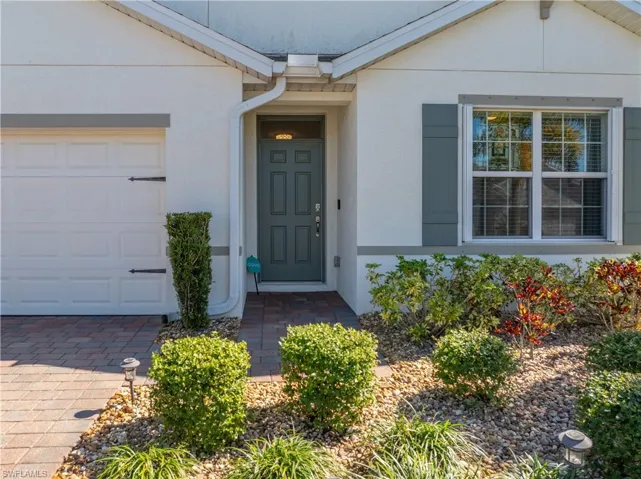 Property entrance featuring stucco siding and a garage
