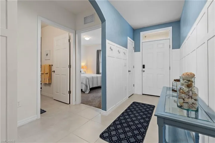 Entryway with arched walkways and light tile patterned flooring