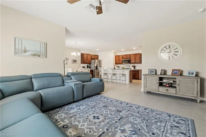 Living room featuring ceiling fan, hanging lights, and light tile patterned flooring
