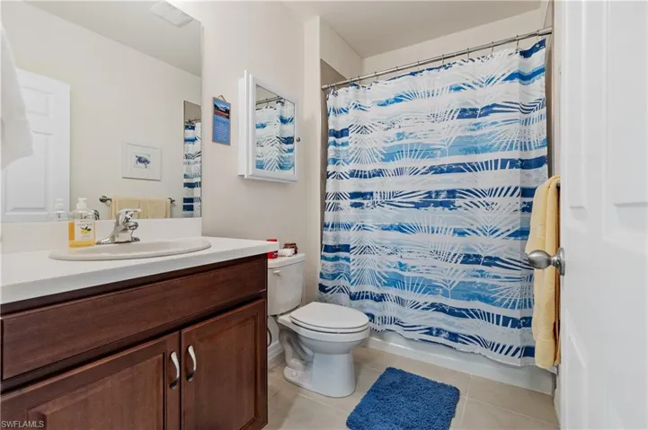 Full bath featuring vanity and light tile patterned flooring