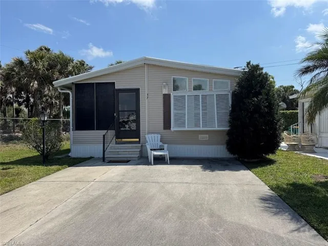 Manufactured / mobile home featuring entry steps, fence, a front lawn, and a sunroom