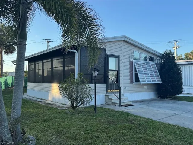 View of front of property with a front lawn and a sunroom
