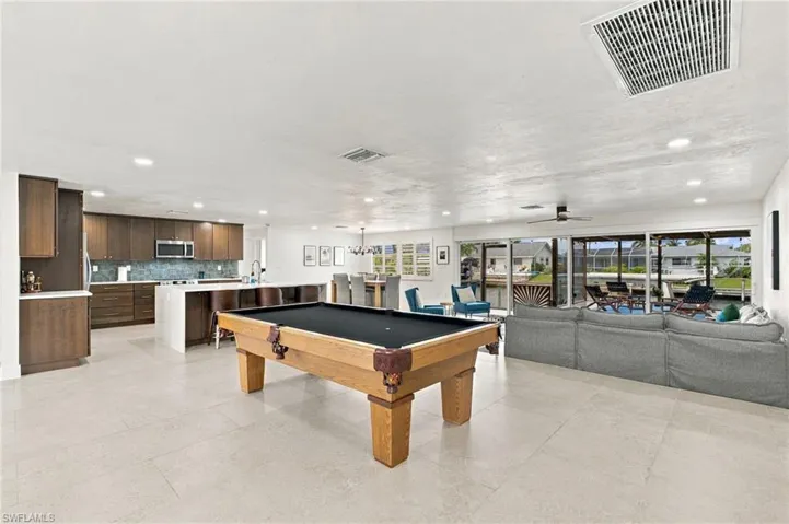 Open-concept living area with light-toned flooring, recessed lighting, and a ceiling fan