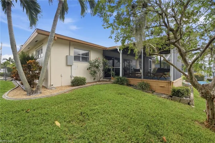Expansive lawn with mature trees and tropical landscaping