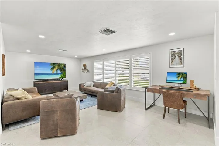Recessed lighting, large windows with plantation shutters, tile flooring, and luxury decor