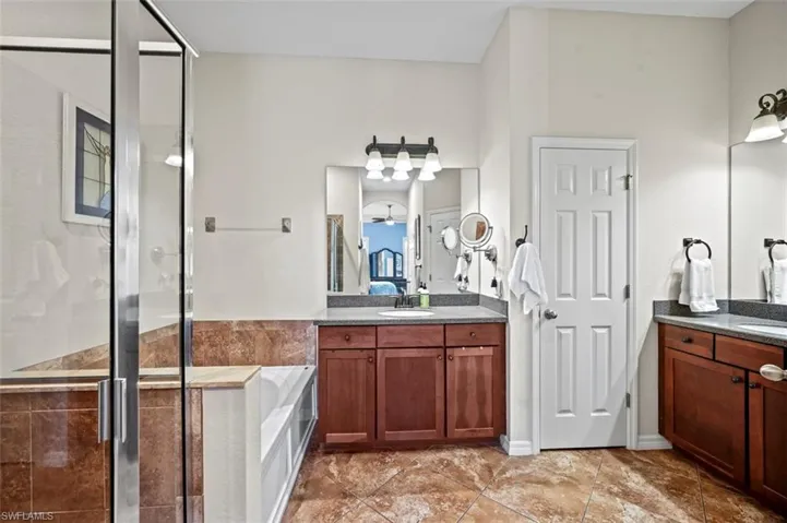 Bathroom featuring vanity, plus walk in shower, and tile patterned floors
