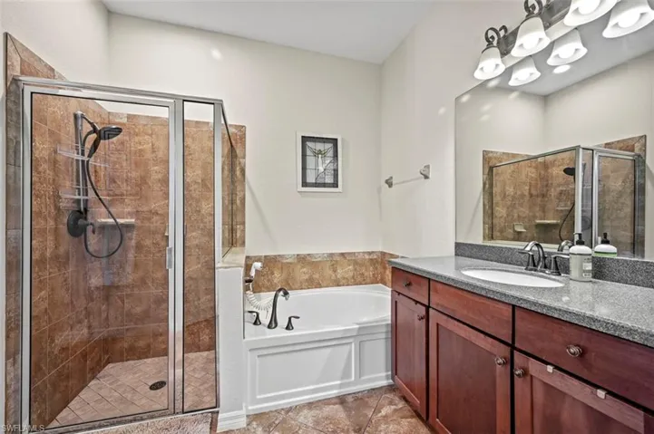 Bathroom featuring separate shower and tub, tile patterned floors, and vanity