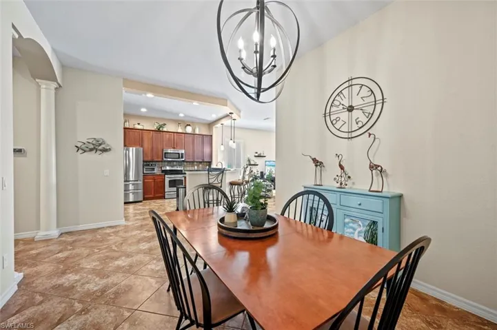 Tiled dining area featuring ornate columns and a chandelier