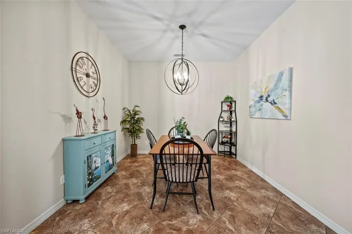 Dining area featuring a notable chandelier and dark tile patterned floors