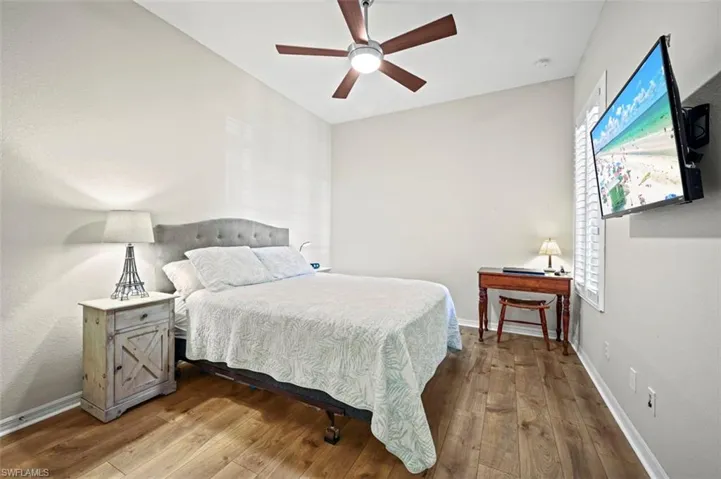 Bedroom with ceiling fan and hardwood / wood-style floors