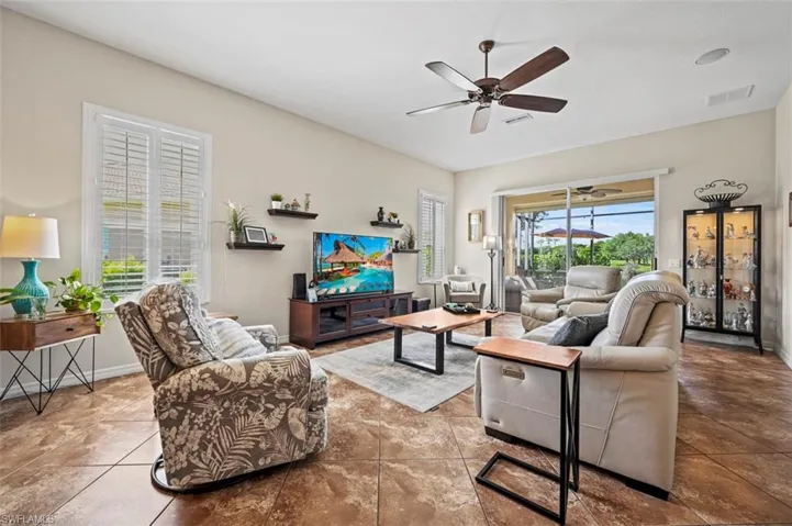 Living room featuring tile patterned floors and ceiling fan