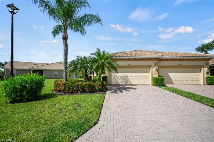 View of front of property with a garage and a front lawn