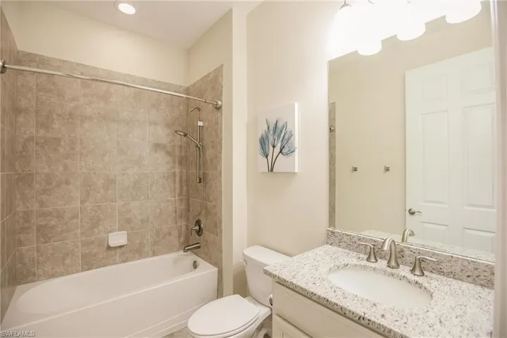 Full bathroom featuring vanity, toilet, and tiled shower / bath