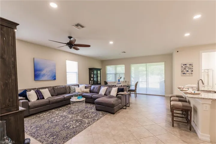 Tiled living room featuring sink, plenty of natural light, and ceiling fan