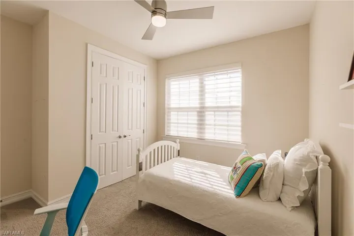 Carpeted bedroom with a closet and ceiling fan