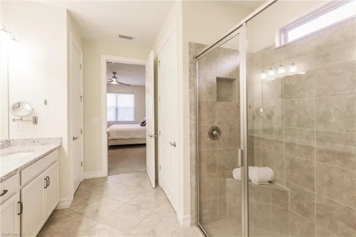 Bathroom featuring vanity, tile patterned floors, and a shower with door