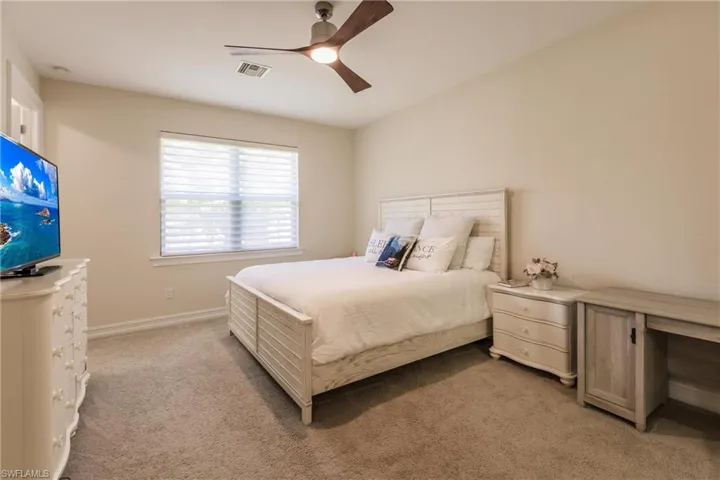Bedroom featuring light carpet and ceiling fan