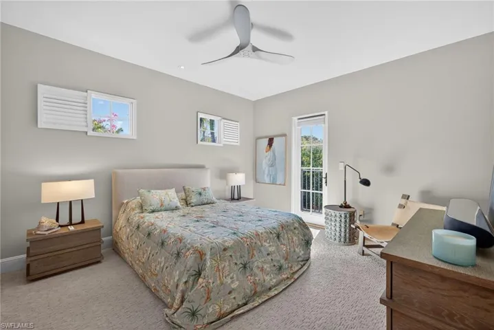 Carpeted bedroom with ceiling fan and baseboards