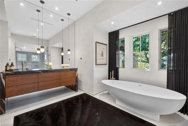 Bathroom with a soaking tub, vanity, recessed lighting, and walk in shower