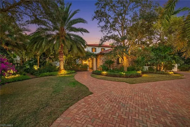 Mediterranean / spanish-style home with a yard and decorative driveway