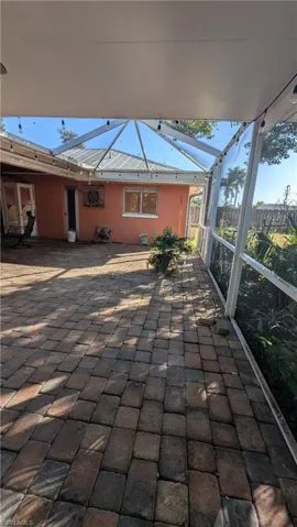 View of patio featuring a sunroom and glass enclosure