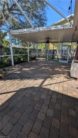 View of patio featuring a sunroom, a lanai, and ceiling fan