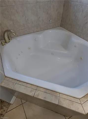 Bathroom with a whirlpool tub and tile patterned flooring