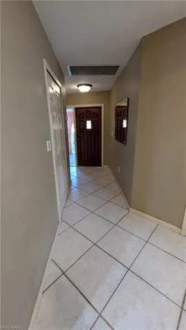 Corridor with light tile patterned floors and baseboards