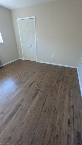 Unfurnished bedroom with wood finished floors and a closet