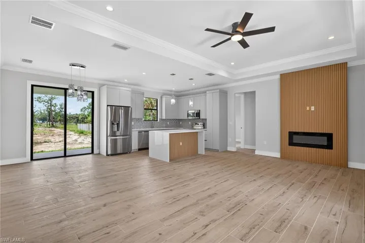 Open-concept living area featuring wood-finish plank flooring, a contemporary ceiling fan, and recessed lighting