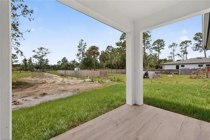 Covered patio featuring wood-finish tile flooring and white support columns