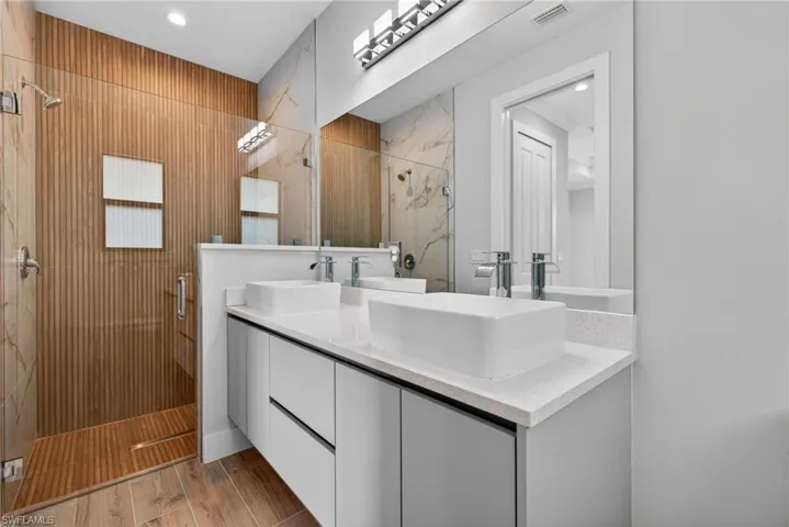 Dual vessel sinks with polished chrome fixtures and a light-colored countertop